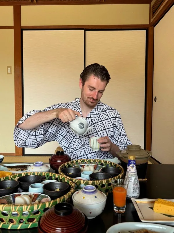 Felix pouring tea at a traditional ryokan breakfast in Hakone, Japan